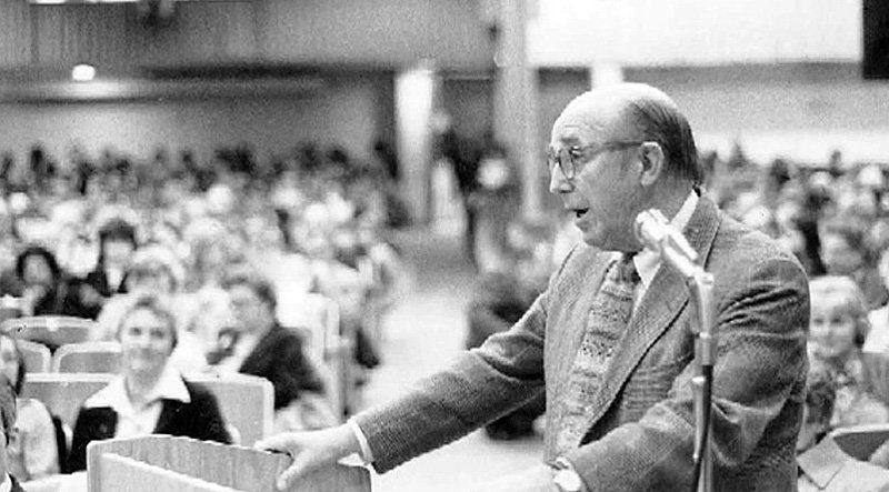 Archival photograph of developer James Rouse speaking at a podium before a large audience.